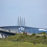 Öresundsbron, bron till Danmark, med bilar och en färja i Öresund.