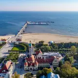 Sopot, Polens riviera, med sin berömda pir som sträcker sig ut i Östersjön. En vacker strand och grönskande parker omger de historiska byggnaderna.