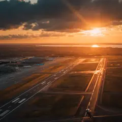 Solnedgång över flygplatsen. En känsla av att ta ett tåg till Kastrup, med flygplan som väntar på start.