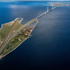 Stora Bältbron, en imponerande bro över havet, med vindkraftverk och en väg som leder över vattnet.
