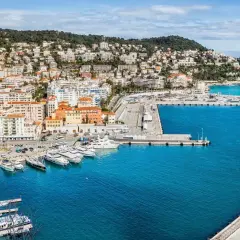 Hamnen i Nice med sina färgglada hus och gröna kullar. En perfekt startpunkt för en resa, kanske till Paris?