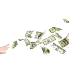 En hand sträcker sig efter flygande dollarsedlar, som om de vore en del av ett äventyr med tågluffarkort Europa.