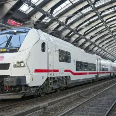 Ett modernt vitt ICE-tåg med röda detaljer står på en station i Hamburg. Tåget är redo att ta passagerare på en resa.