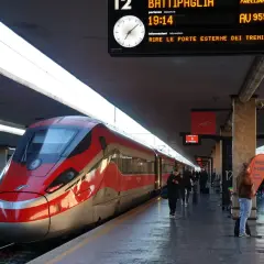 Rött höghastighetståg på en station, redo för avgång till Sicilien.