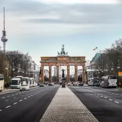 Brandenburger Tor och TV-tornet syns tydligt under en resa till Berlin. Bussar och bilar trafikerar gatan.