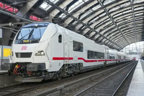 Ett modernt vitt ICE-tåg med röda detaljer står på en station i Hamburg. Tåget är redo att ta passagerare på en resa.