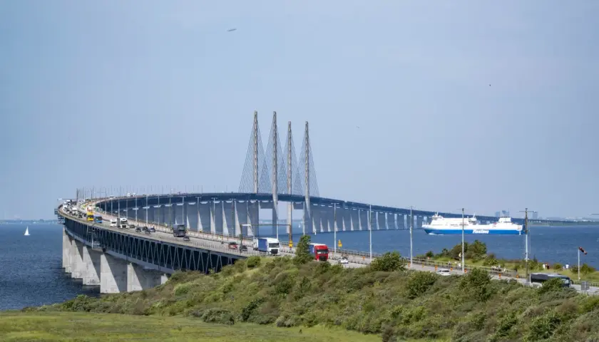 Öresundsbron, bron till Danmark, med bilar och en färja i Öresund.