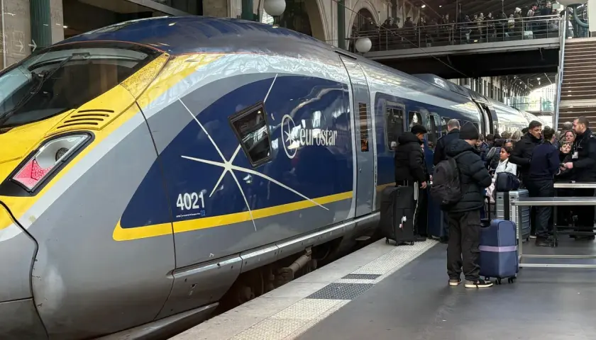 Eurostar-tåget står redo för en resa i Europa. Passagerare med bagage väntar på perrongen.