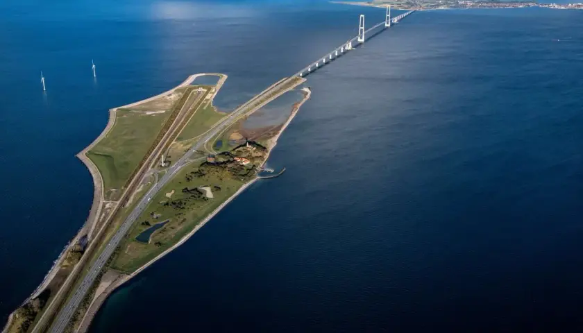 Stora Bältbron, en imponerande bro över havet, med vindkraftverk och en väg som leder över vattnet.