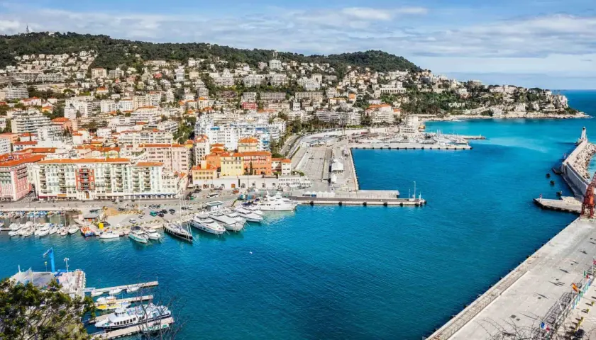 Hamnen i Nice med sina färgglada hus och gröna kullar. En perfekt startpunkt för en resa, kanske till Paris?