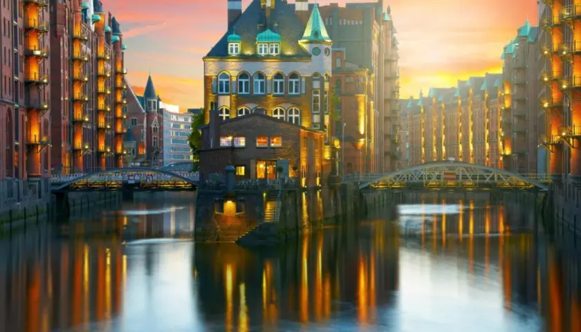 Vackra tegelbyggnader längs en kanal i Hamburg vid solnedgången. Perfekt för en weekend i Hamburg.