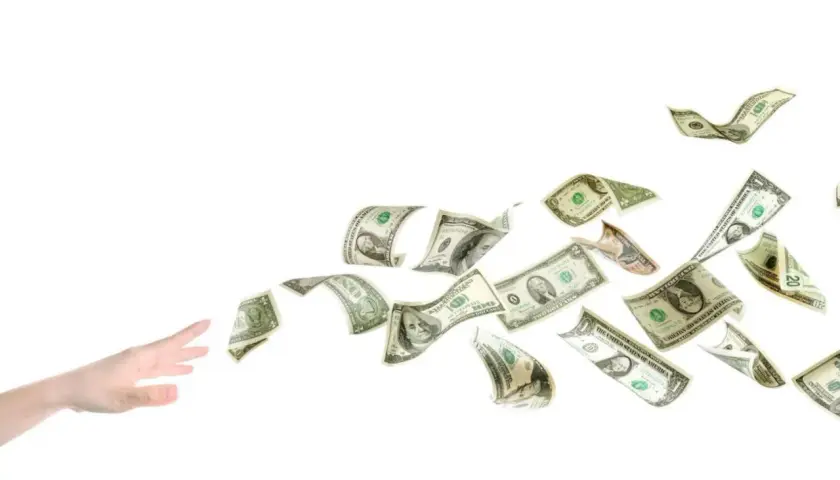 En hand sträcker sig efter flygande dollarsedlar, som om de vore en del av ett äventyr med tågluffarkort Europa.