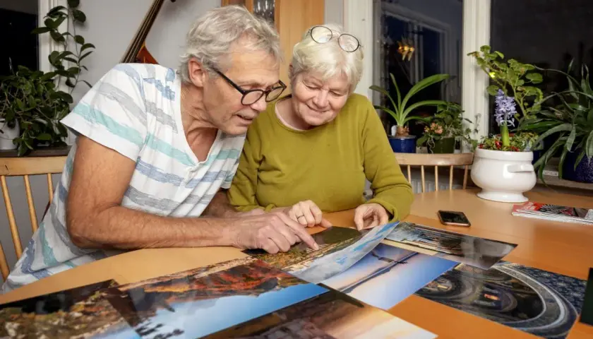 Ett pensionärspar tittar på bilder från en Interrailresa. De planerar kanske nästa äventyr.