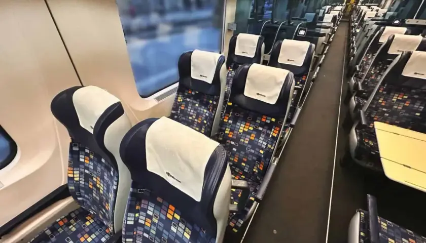 Tomma säten i en nattåg till München. Mörka säten med färgglatt mönster och vita nackstöd.