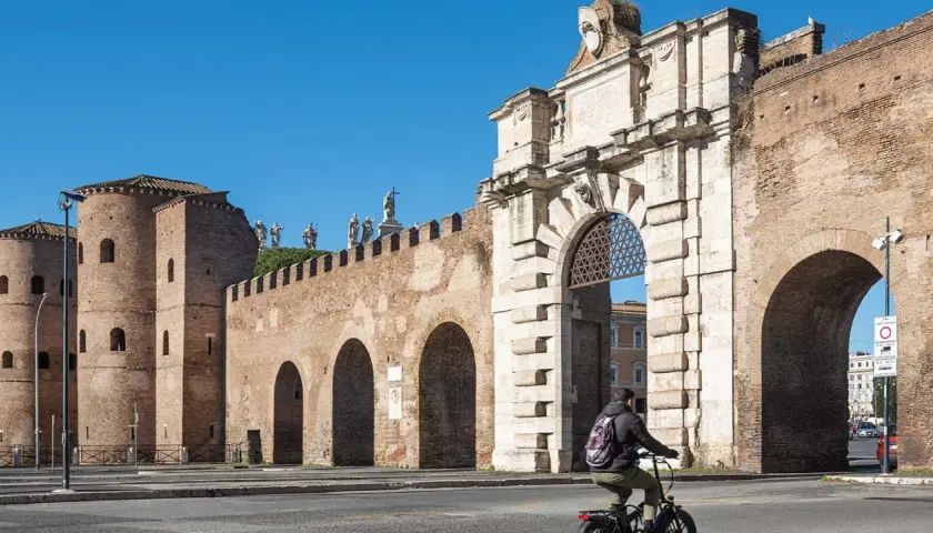 En cyklist passerar Porta San Sebastiano, en del av det antika kvarteret i Rom.