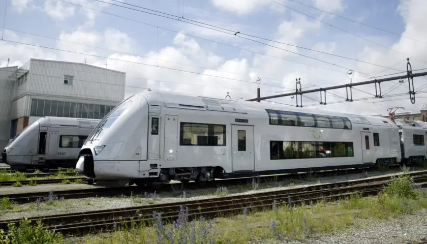 Två moderna SJ-tåg står uppställda på spåret. Ett av tågen har texten "TEST" på sidan, redo för äventyr med ett sj tågluffarkort.