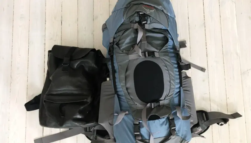 Två ryggsäckar, en stor blå och en mindre svart, redo för en packlista tågluff.