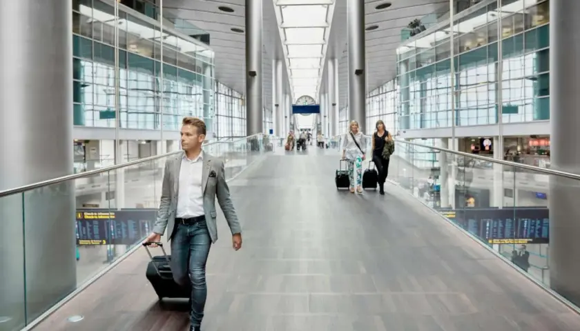 Man med resväska på en flygplats, kanske på väg till ett tåg till Fredrikshamn eller Aalborg.