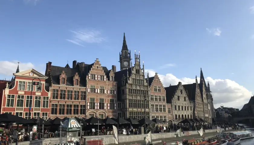 Vacker kanalvy i Gent, Belgien, med historiska byggnader och båtar som ligger vid kajen.
