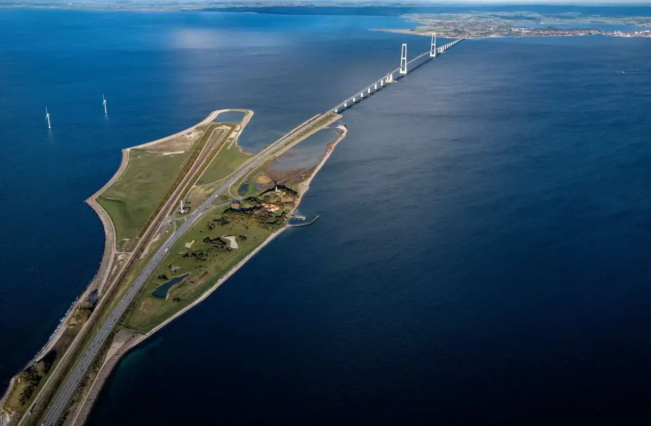 Stora Bältbron, en imponerande bro över havet, med vindkraftverk och en väg som leder över vattnet.