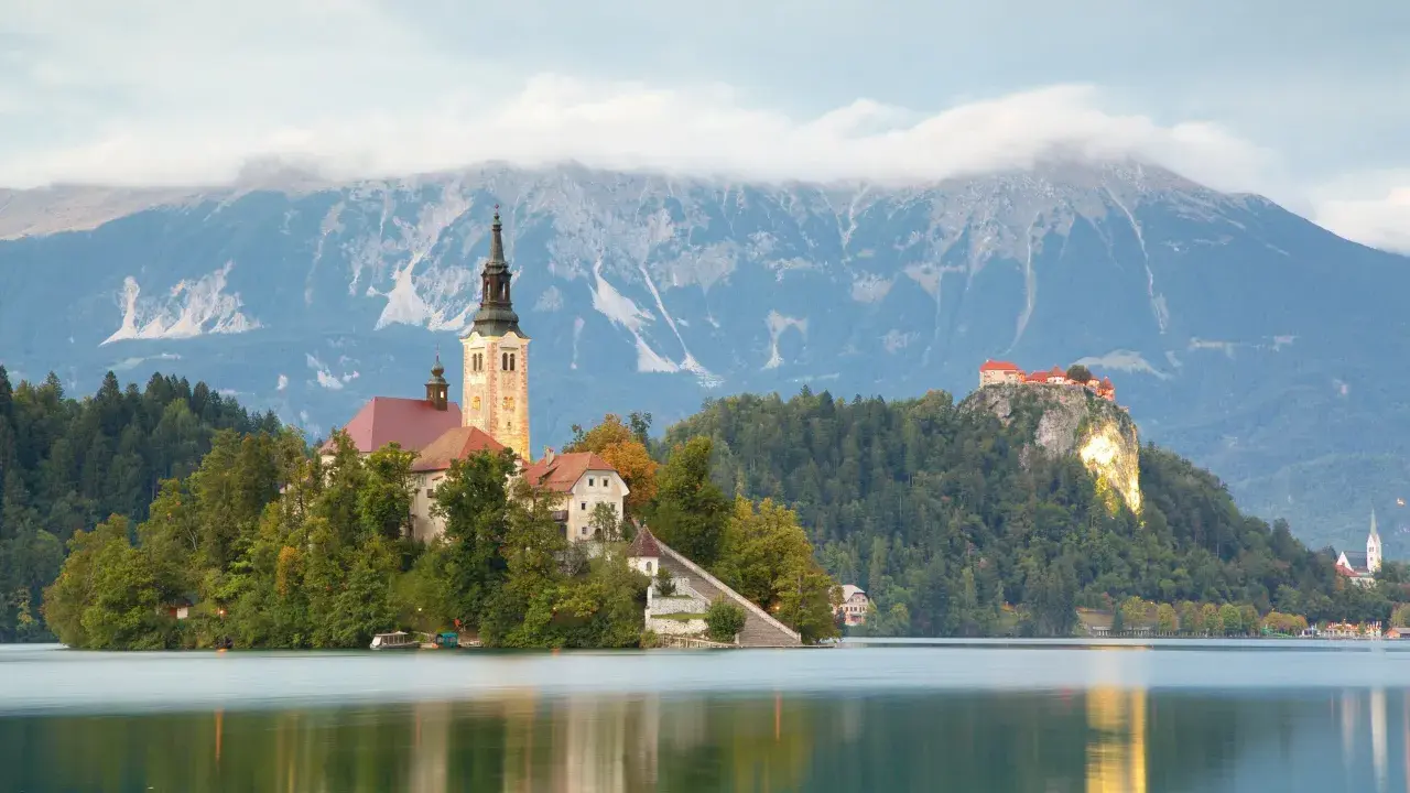 En vacker vy över Bleds ö med kyrka och slott, en dröm för en **slovenien resa**.