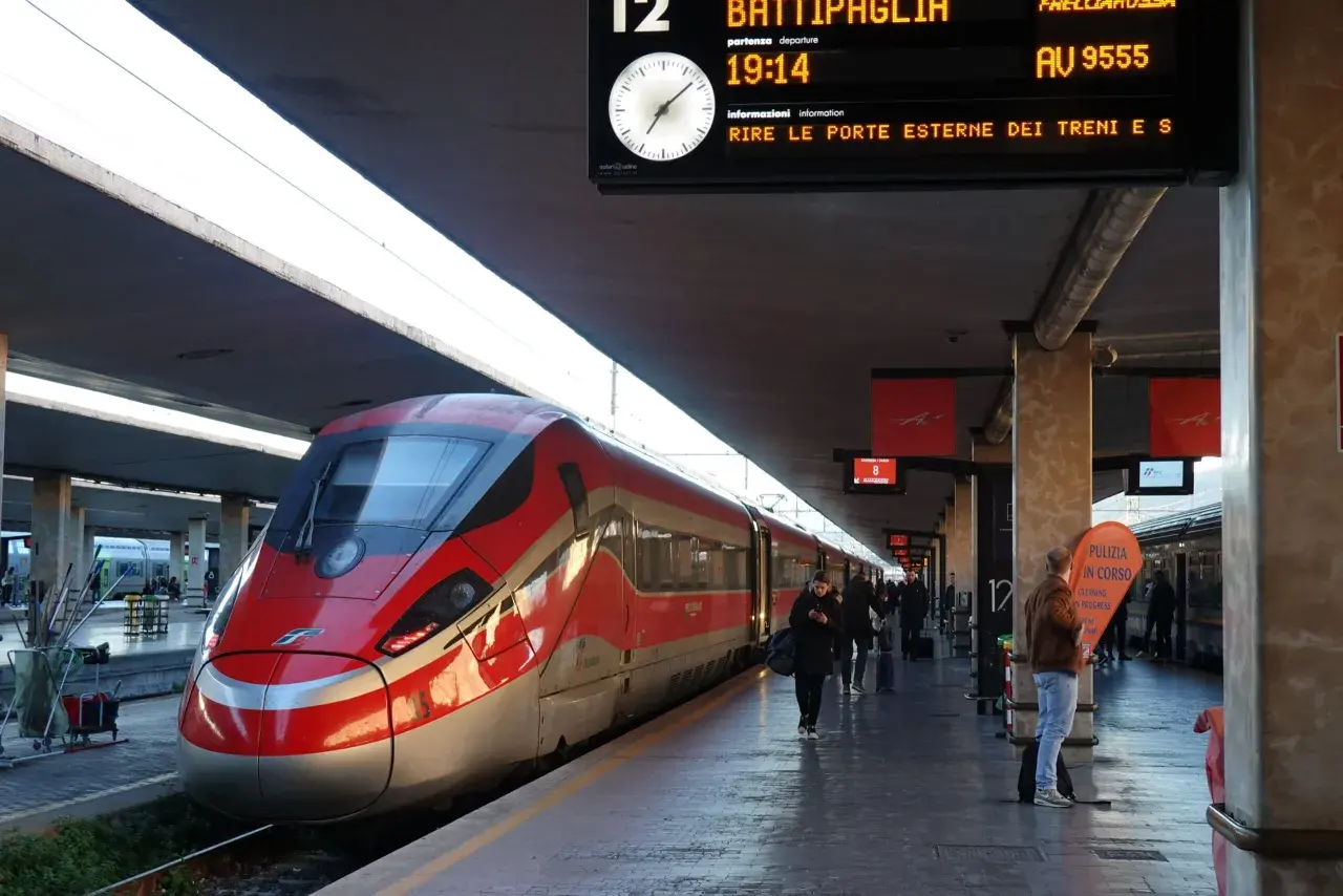 Rött höghastighetståg på en station, redo för avgång till Sicilien.