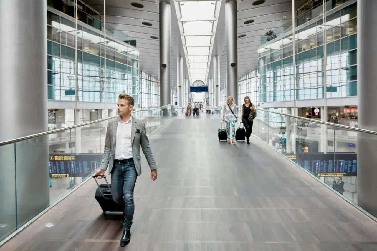 Man med resväska på en flygplats, kanske på väg till ett tåg till Fredrikshamn eller Aalborg.
