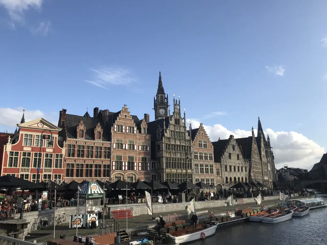 Vacker kanalvy i Gent, Belgien, med historiska byggnader och båtar som ligger vid kajen.