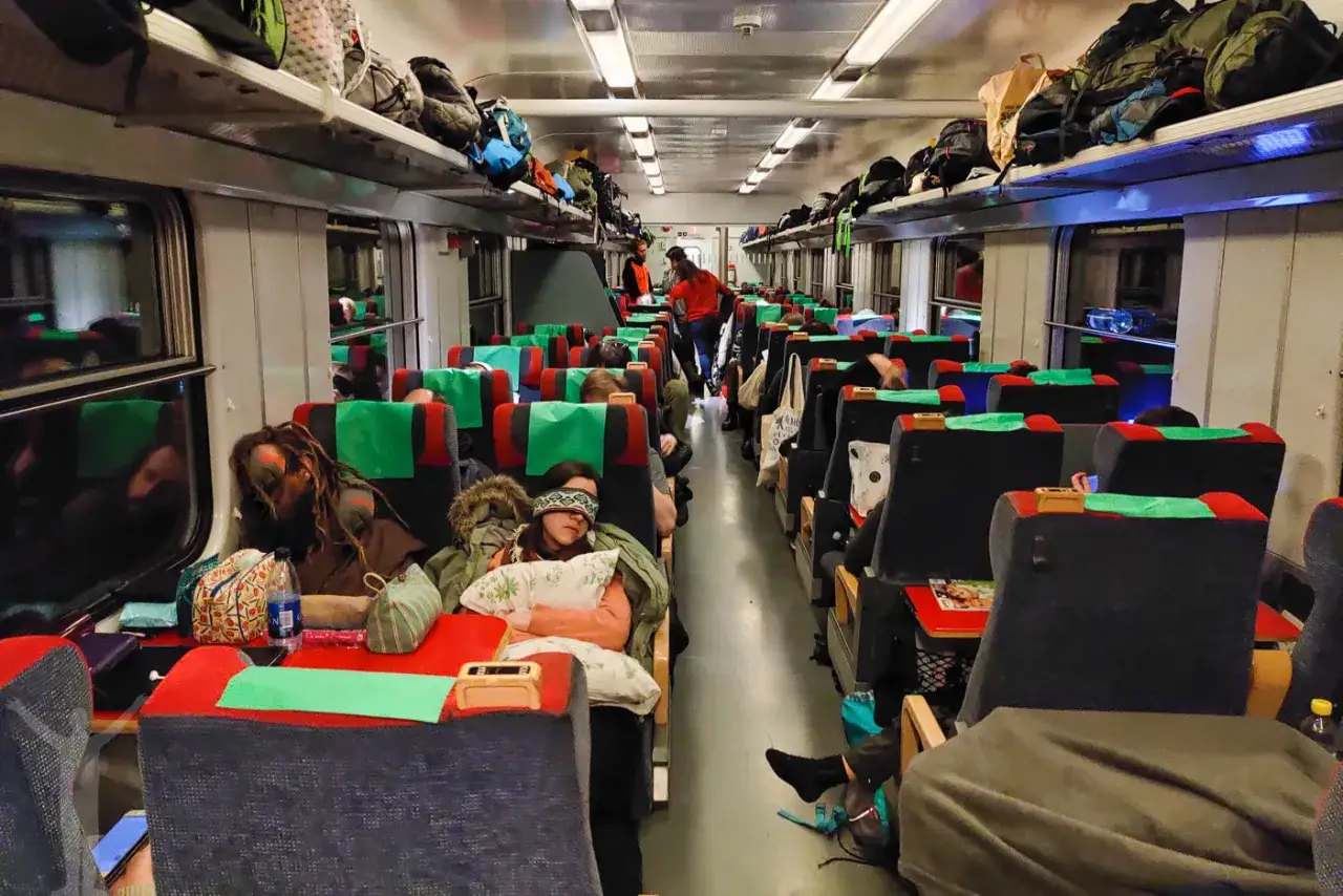 Sovande passagerare i en SJ sovvagn 2 klass. Bagage på hyllorna ovanför sätena.