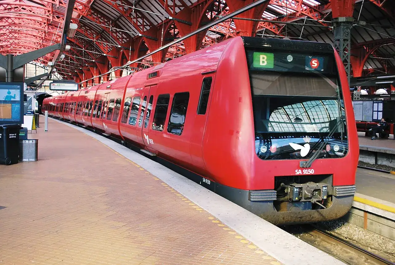 Rött DSB-tåg står redo på stationen, perfekt för en weekendresa till Köpenhamn med tåg.