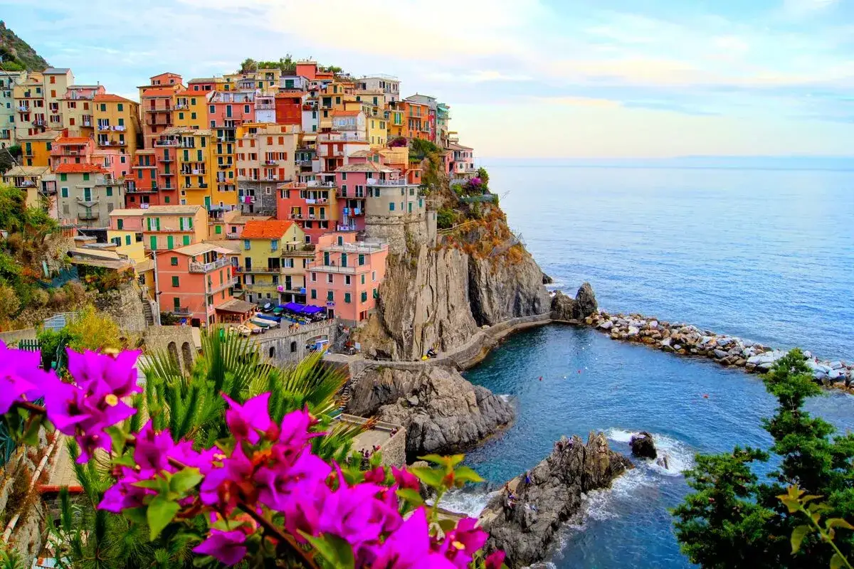 Färgstarka hus klättrar uppför klipporna vid Cinque Terre, med det blå havet som omger dem.