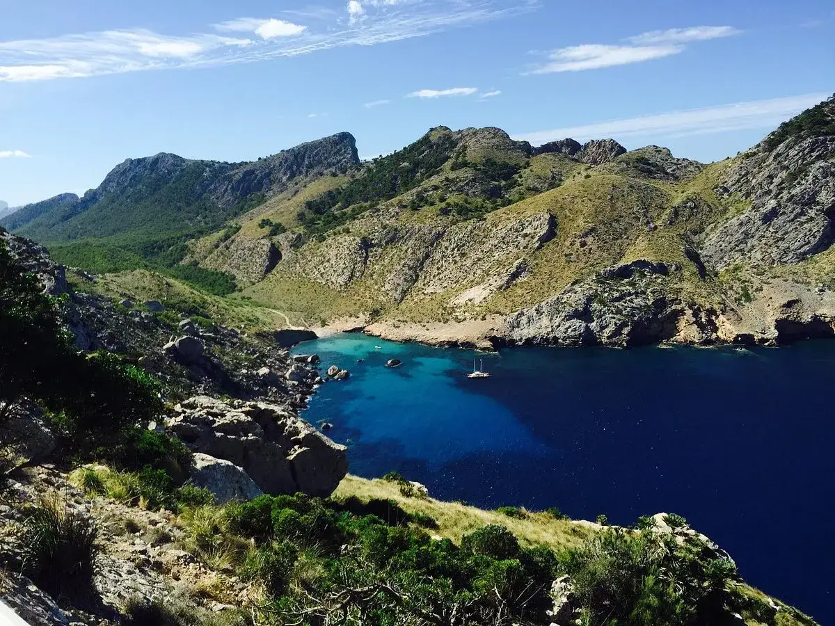 Vacker vy över en vik med turkost vatten och berg. Perfekt för att vandra på Mallorca och njuta av naturen.