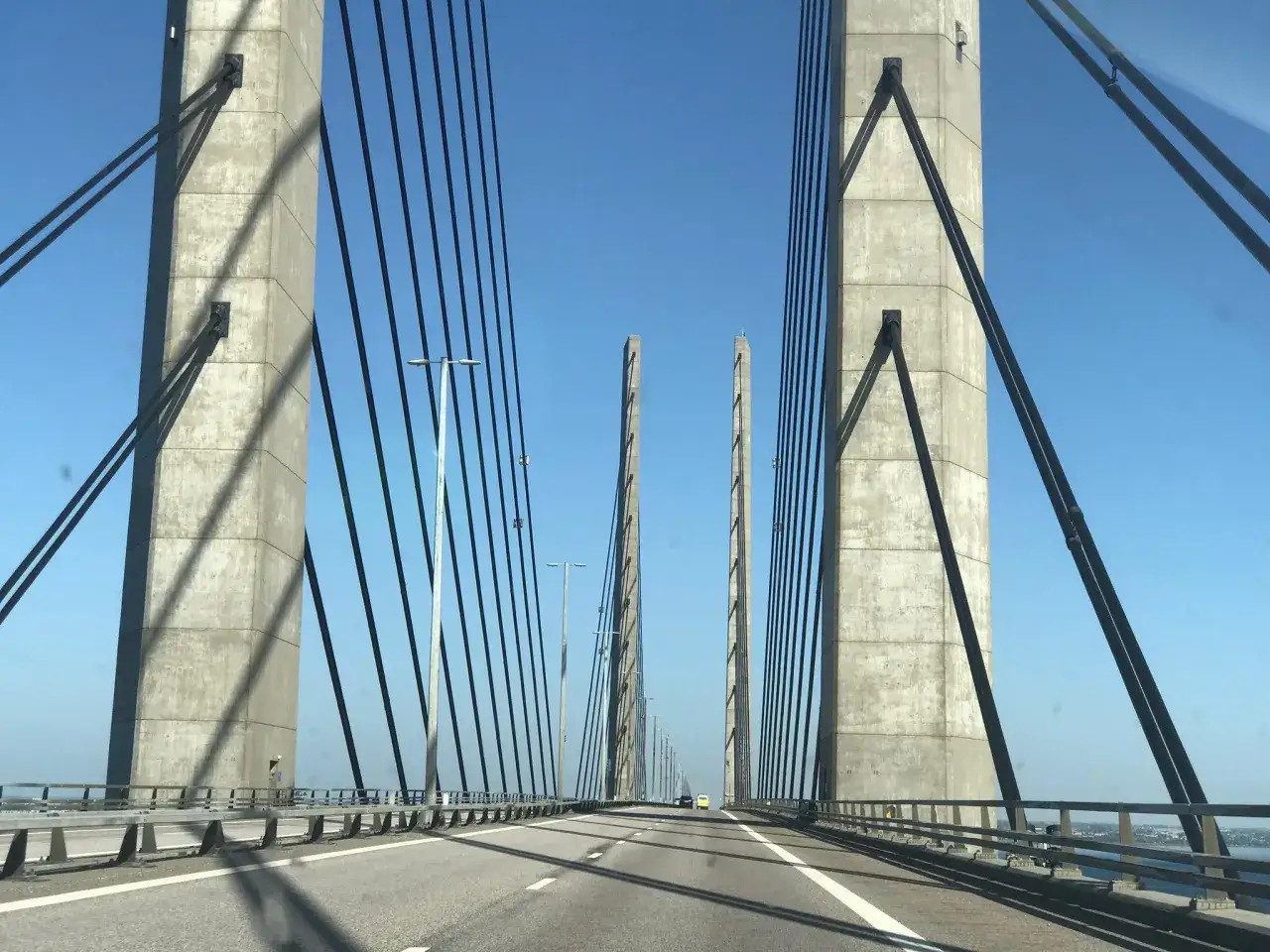 Kör över Öresundsbron med nya priser. Betongpelare och vajrar mot en klarblå himmel.
