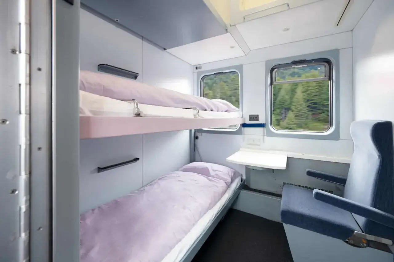 Sovkupé på ett nattåg till Berlin med två våningssängar och utsikt över skogen.